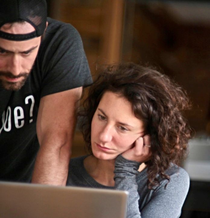 Two teammates working together at a laptop